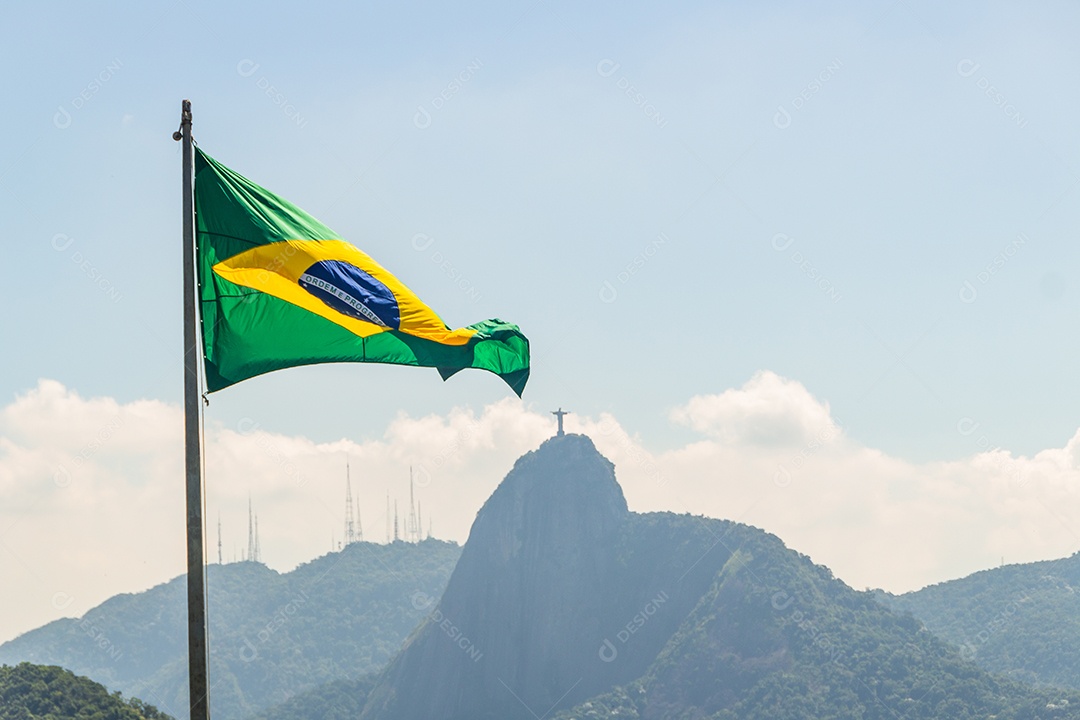 bandeira do brasil com imagem de cristo redentor ao fundo no rio de janeiro brasil.
