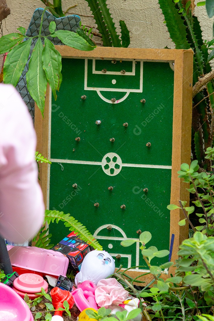 jogo de tabuleiro conhecido como dedobol, que simula uma partida de futebol com pregos representando os jogadores e uma moeda como uma bola.