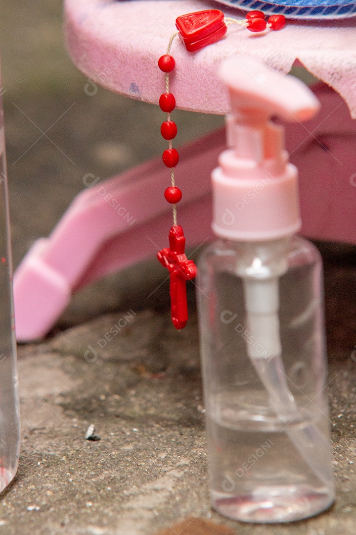 terço vermelho ao lado de um tubo de álcool gel, proteção contra coronavírus no Brasil.