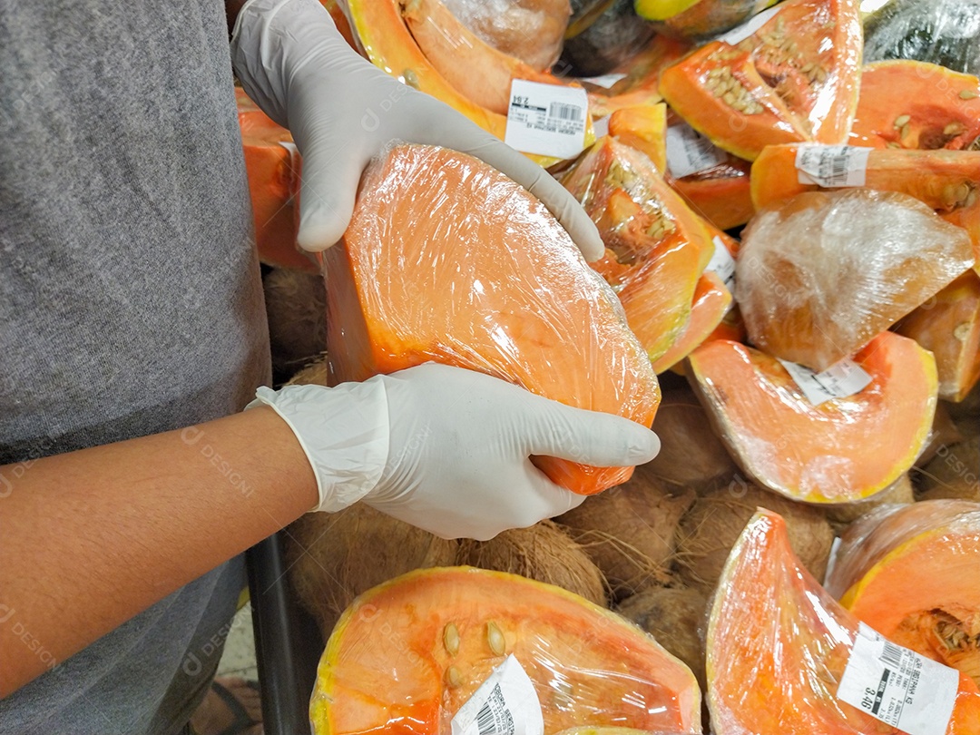 homem negro com luvas escolhendo abóbora com luva, proteção contra coronavírus no Brasil.