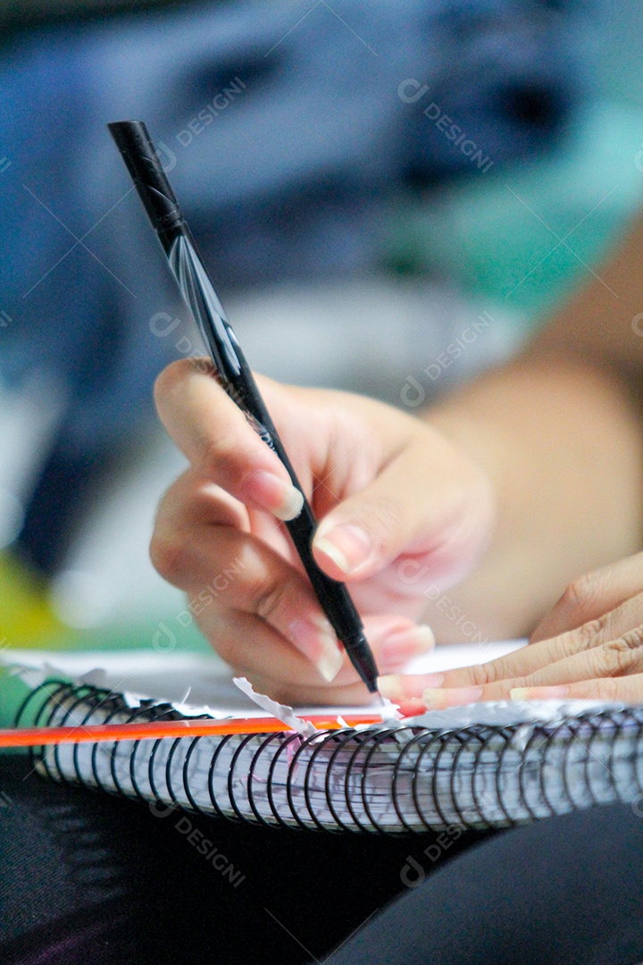 mulher com caneta na mão desenhando no caderno no rio de janeiro.