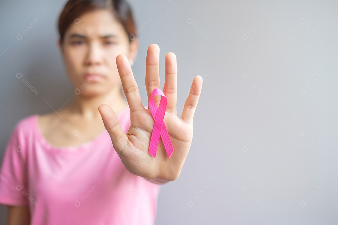 Outubro Mês de conscientização do câncer de mama, idosa Mulher de camiseta rosa com a mão segurando a fita rosa para apoiar as pessoas que vivem e estão doentes.