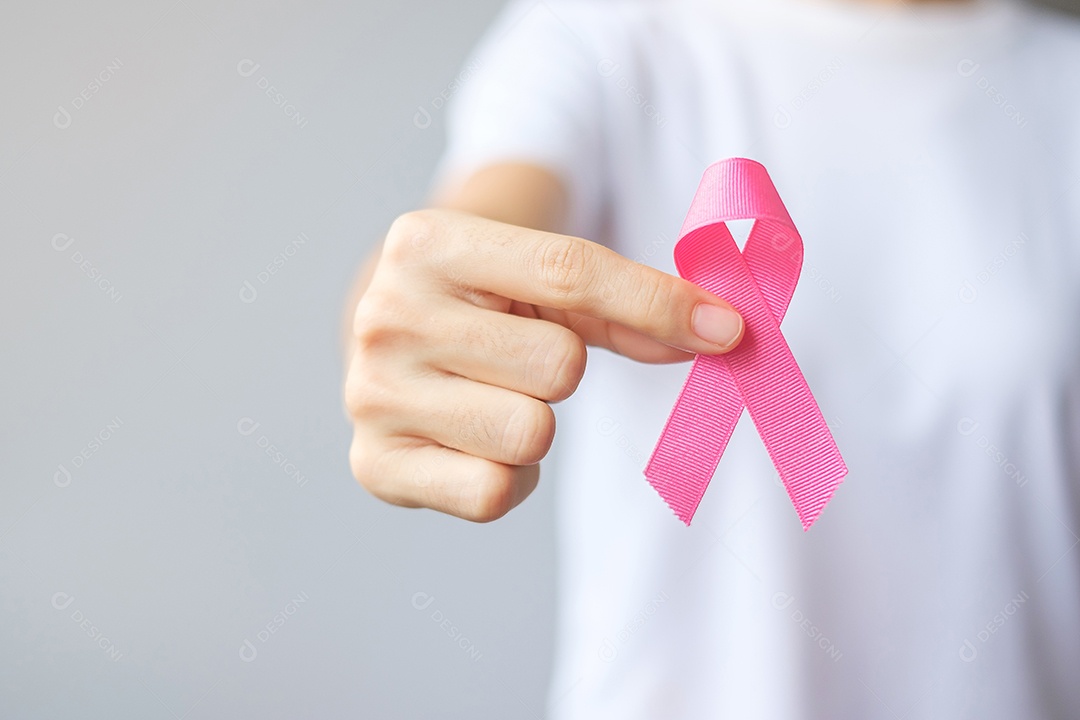 Mês de conscientização do câncer de mama de outubro, mulher idosa de camiseta branca com a mão segurando a fita rosa para apoiar as pessoas que vivem e estão doentes.