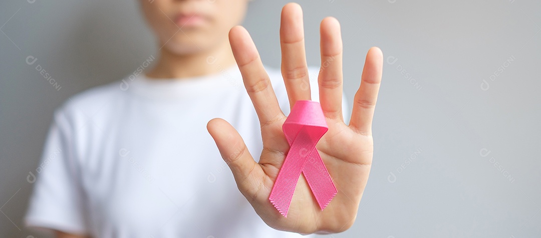 Mês de conscientização do câncer de mama de outubro, mulher idosa de camiseta branca com a mão segurando a fita rosa para apoiar as pessoas que vivem e estão doentes.