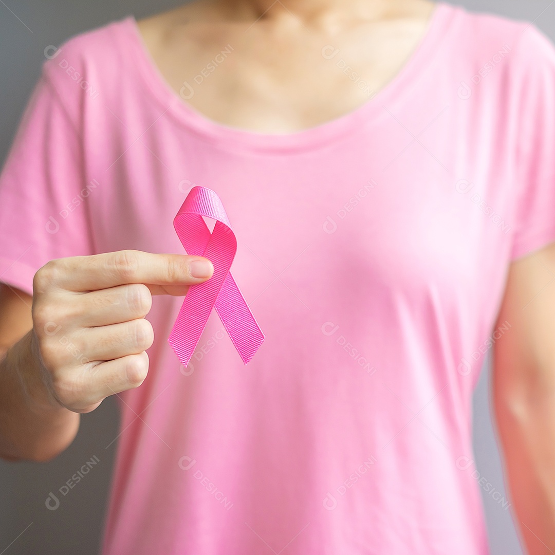 Outubro Mês de conscientização do câncer de mama, idosa Mulher de camiseta rosa com a mão segurando a fita rosa para apoiar as pessoas que vivem e estão doentes.