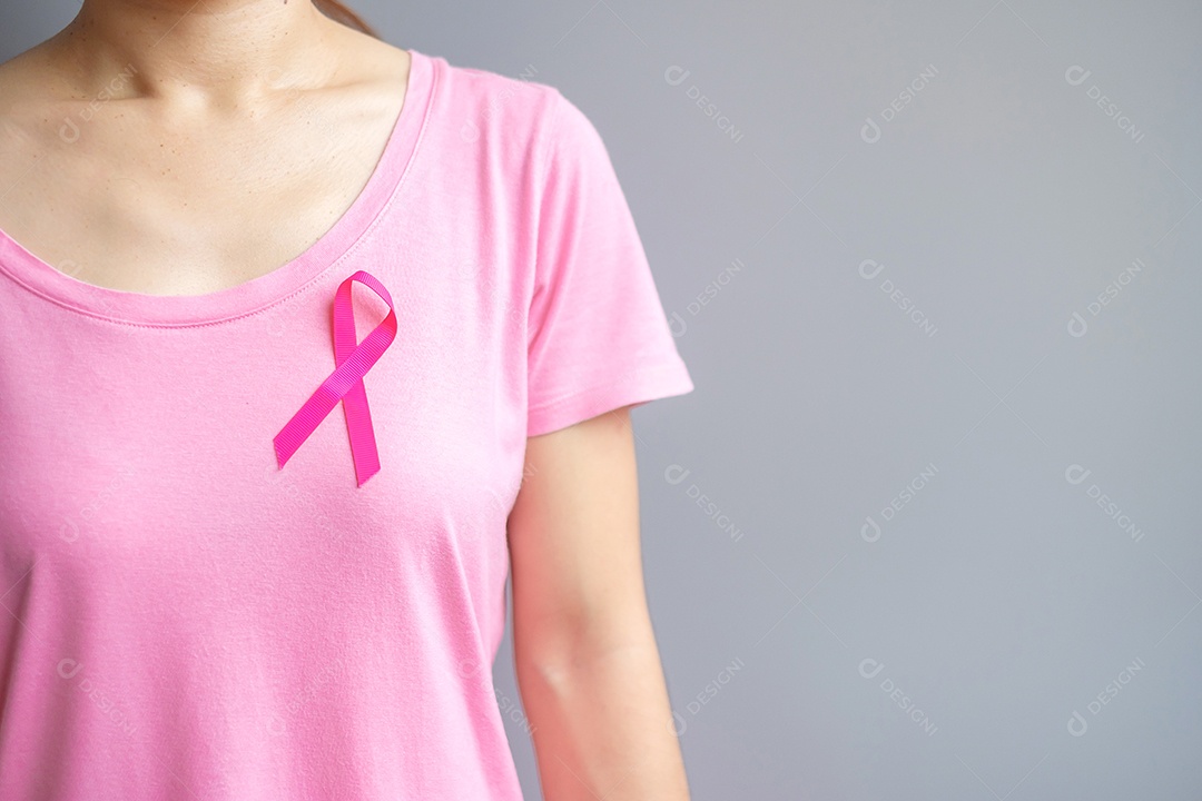 Outubro Mês de conscientização do câncer de mama, idosa Mulher de camiseta rosa com a mão segurando a fita rosa para apoiar as pessoas que vivem e estão doentes.