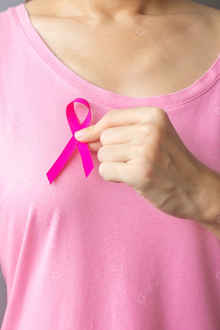 Outubro Mês de conscientização do câncer de mama, idosa Mulher de camiseta rosa com a mão segurando a fita rosa para apoiar as pessoas que vivem e estão doentes.