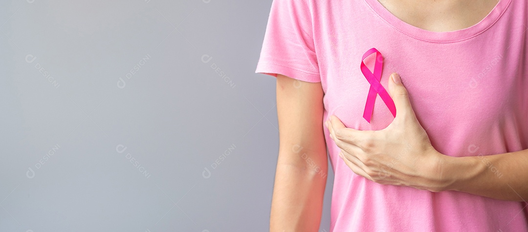 October Breast Cancer Awareness Month, Elderly Woman in pink t-shirt with hand holding pink ribbon to support people who are living and sick.