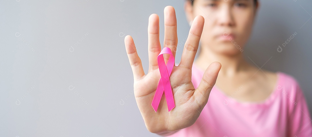 Outubro Mês de conscientização do câncer de mama, idosa Mulher de camiseta rosa com a mão segurando a fita rosa para apoiar as pessoas que vivem e estão doentes.