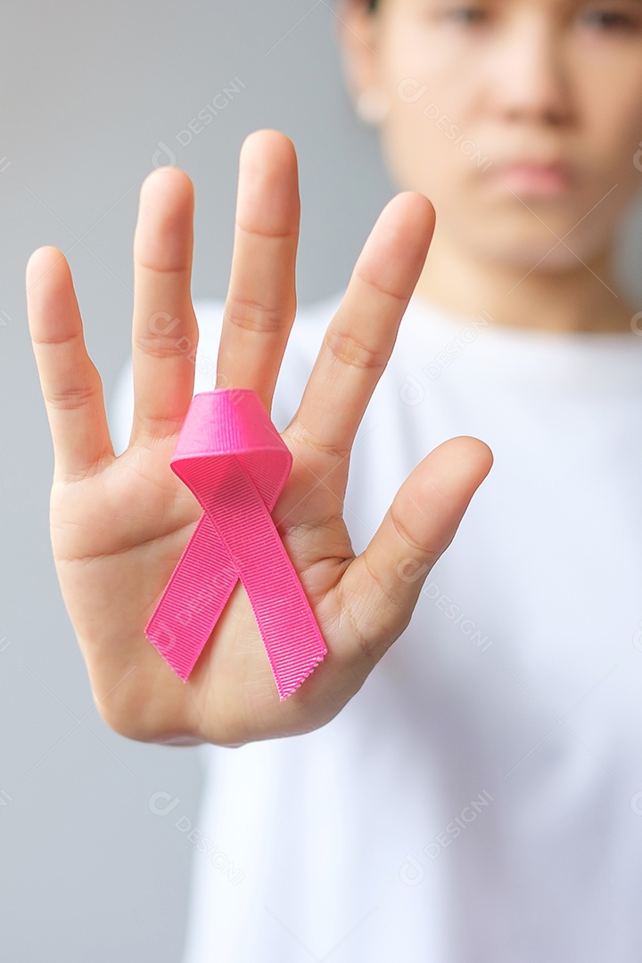 Mês de conscientização do câncer de mama de outubro, mulher idosa de camiseta branca com a mão segurando a fita rosa para apoiar as pessoas que vivem e estão doentes.