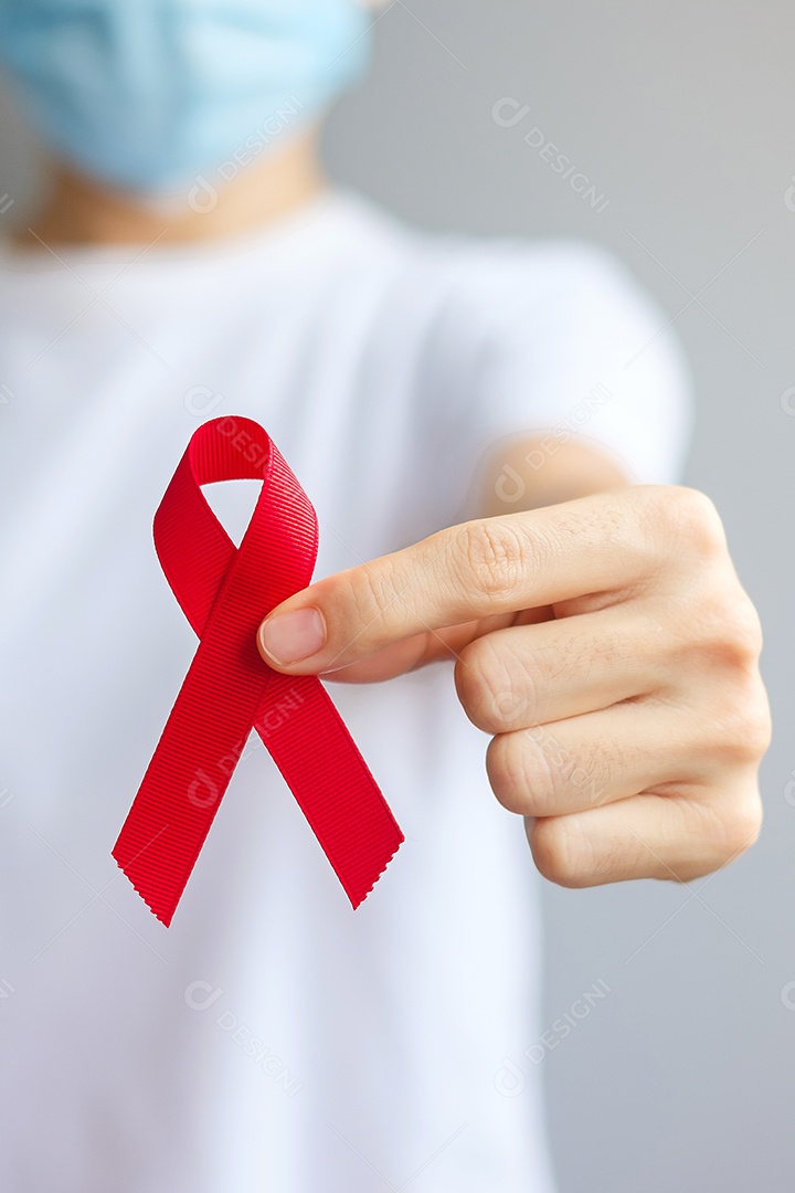 Mão segurando a fita vermelha para dezembro Dia Mundial da Aids (síndrome da imunodeficiência adquirida), mês de conscientização do câncer de mieloma múltiplo e semana nacional da fita vermelha.