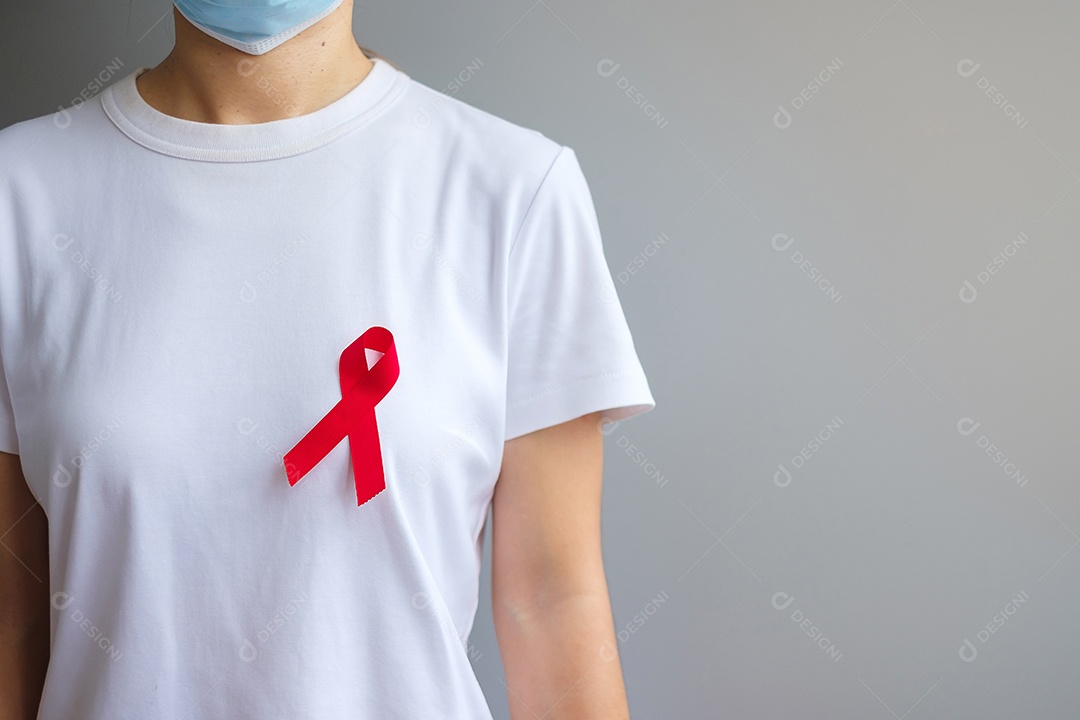 Mão segurando a fita vermelha para dezembro Dia Mundial da Aids (síndrome da imunodeficiência adquirida), mês de conscientização do câncer de mieloma múltiplo e semana nacional da fita vermelha.
