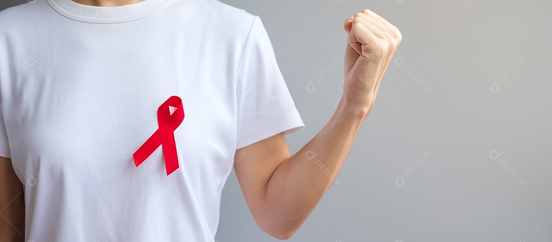 Mão segurando a fita vermelha para dezembro Dia Mundial da Aids (síndrome da imunodeficiência adquirida), mês de conscientização do câncer de mieloma múltiplo e semana nacional da fita vermelha.