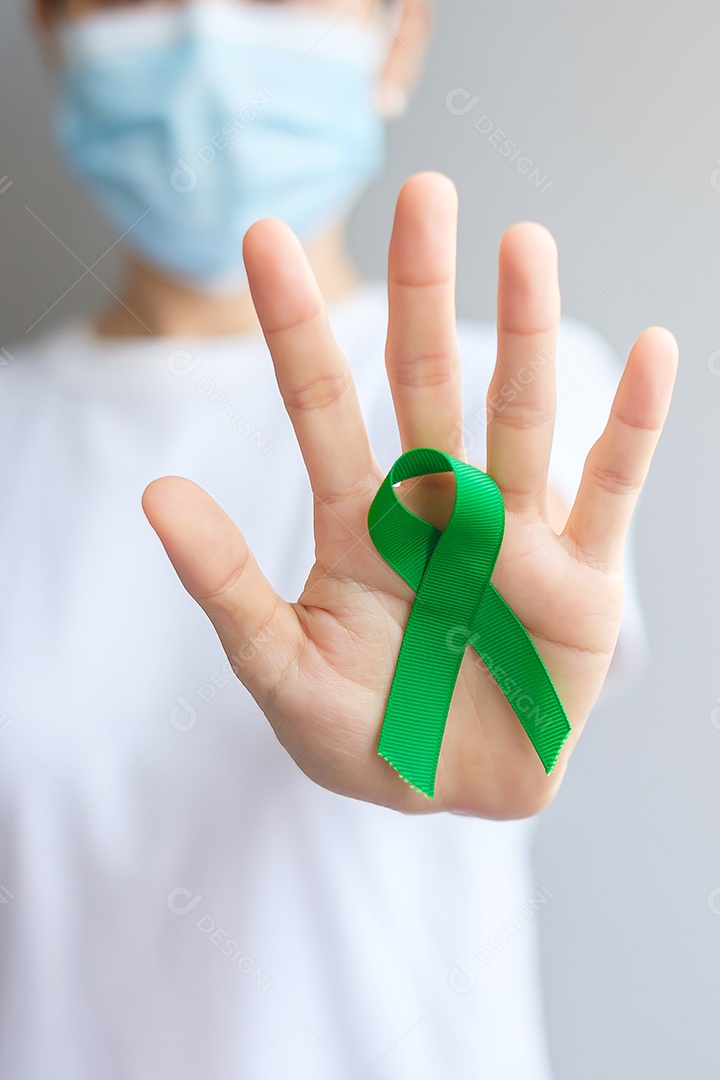 Mão segurando a fita verde para fígado, vesícula biliar, ducto biliar, cervical, câncer renal e mês de conscientização do linfoma. Conceito de saúde e dia mundial do câncer