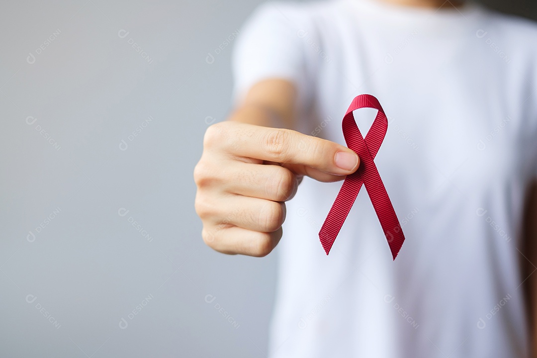 Mão segurando a fita vermelha da Borgonha para março, mieloma múltiplo, câncer e dezembro, mês de conscientização do Dia Mundial da Aids. Conceito de saúde e dia mundial do câncer
