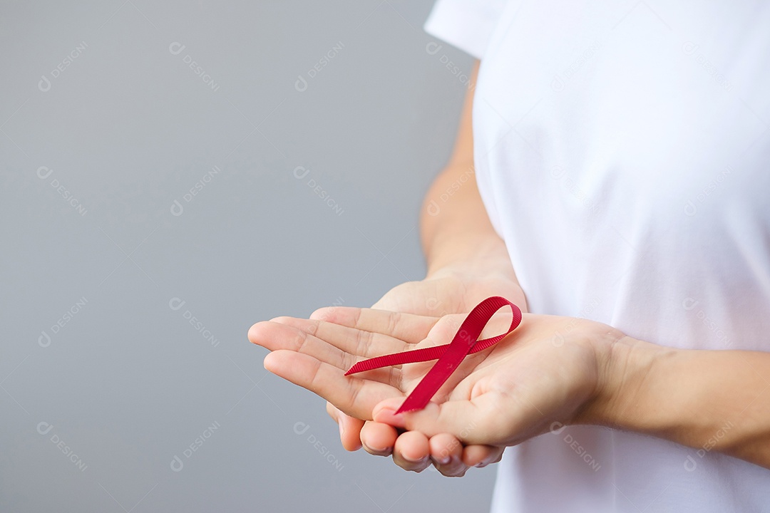 Mão segurando a fita vermelha da Borgonha para março, mieloma múltiplo, câncer e dezembro, mês de conscientização do Dia Mundial da Aids. Conceito de saúde e dia mundial do câncer
