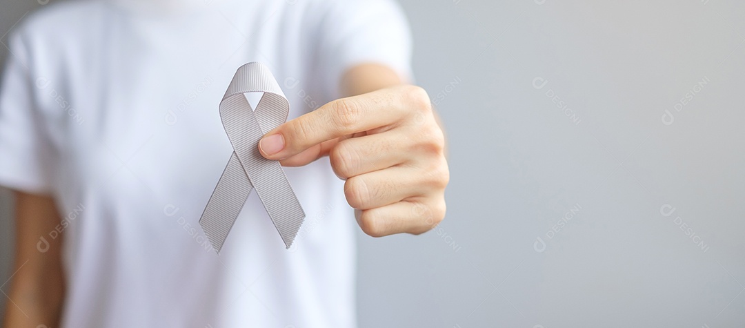 Mês de conscientização do câncer cerebral, mão de mulher segurando fita de cor cinza para apoiar as pessoas que vivem. Conceito de saúde e dia mundial do câncer