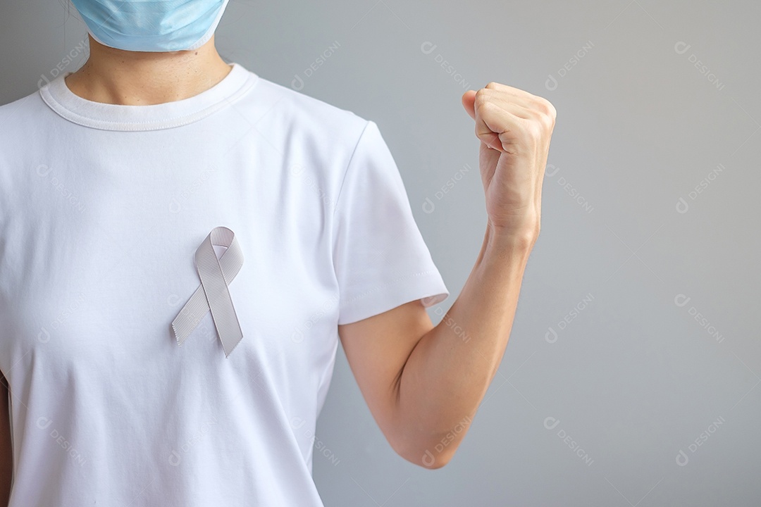 Mês de conscientização do câncer cerebral, mão de mulher segurando fita de cor cinza para apoiar as pessoas que vivem. Conceito de saúde e dia mundial do câncer