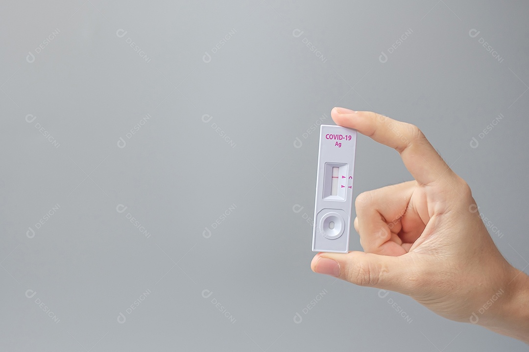 Homem segurando o kit de teste rápido de antígeno com resultado negativo durante.