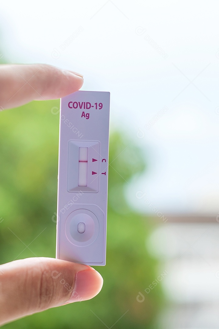 Homem segurando o kit de teste rápido de antígeno com resultado negativo durante o resultado durante s