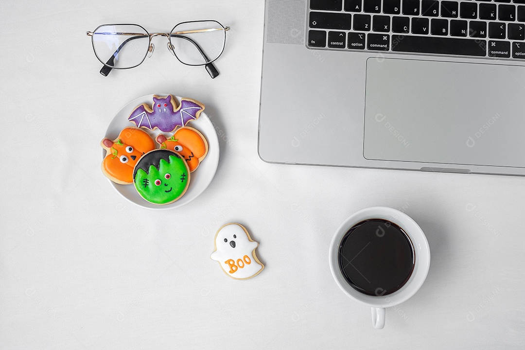 Cookies de Halloween, café quente e computador portátil em fundo branco. Feliz dia das bruxas, compras online, Olá outubro, outono outono, festivo, festa e conceito de férias