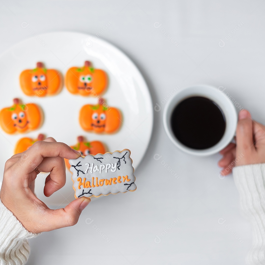 Mão de mulher segurando engraçado Halloween Cookie durante o café. Feliz dia de Halloween, truque ou ameaça, Olá outubro, outono outono, tradicional, festa e conceito de férias