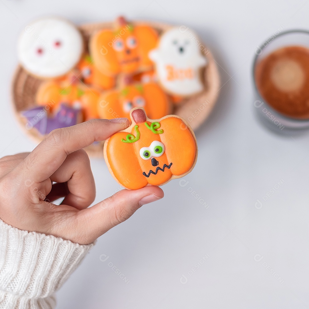 Mão de mulher segurando engraçado Halloween Cookie durante o café. Feliz dia de Halloween, truque ou ameaça, Olá outubro, outono outono, tradicional, festa e conceito de férias