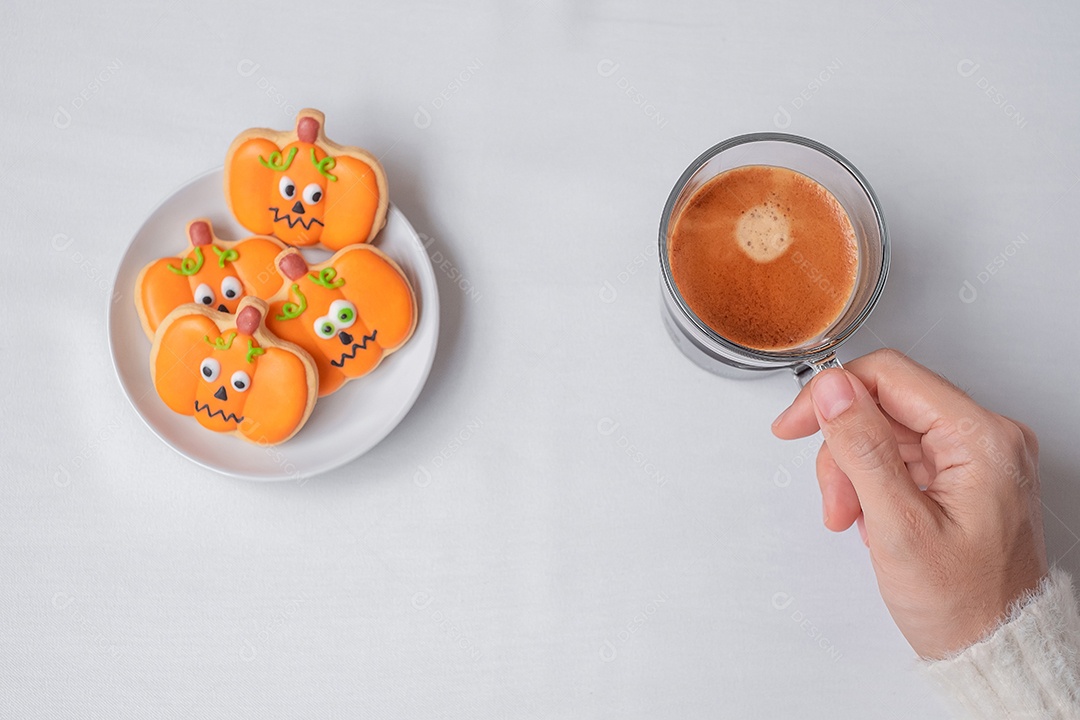 Mão de mulher segurando a xícara de café durante comer engraçado Halloween Cook