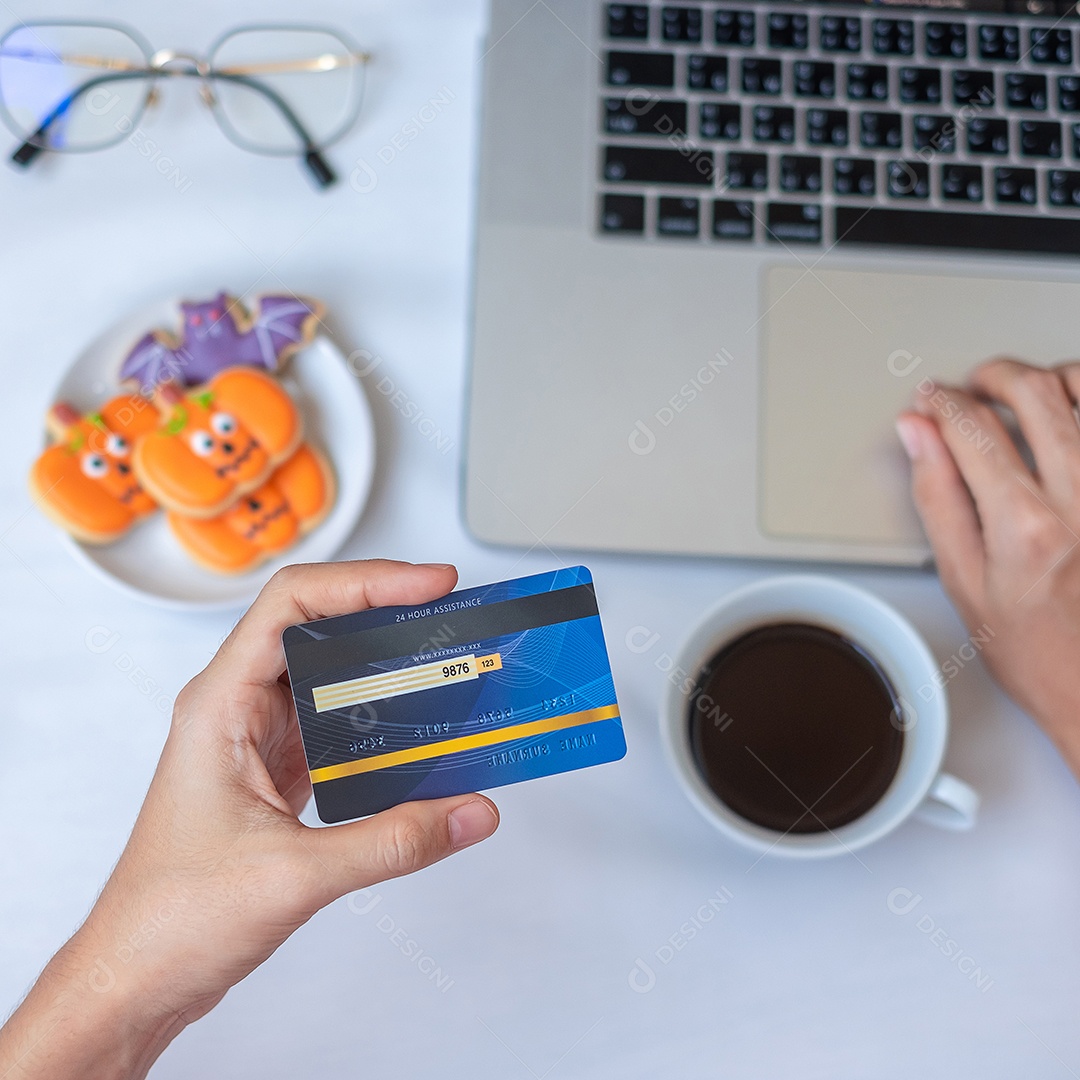 Mão segurando o cartão de crédito para compras on-line no laptop durante.