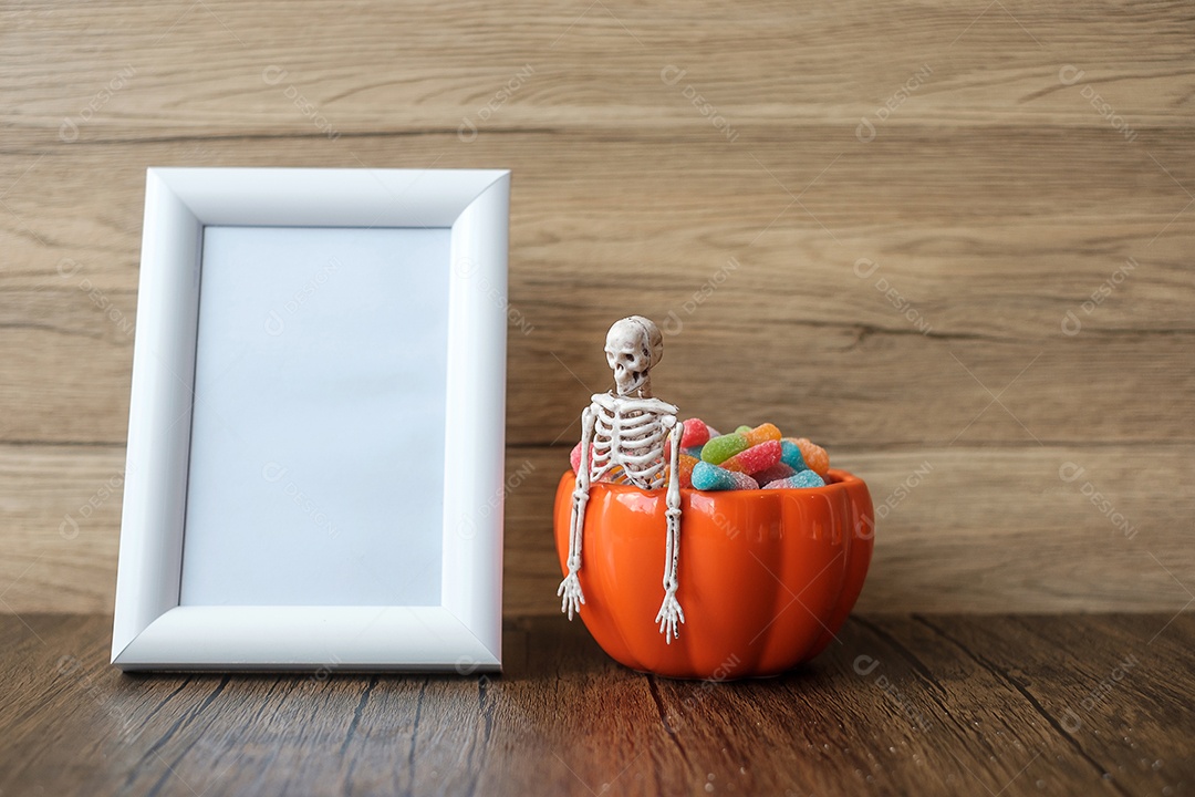 Tigela de abóbora laranja e doces na mesa e moldura com espaço de cópia para texto. Feliz dia de Halloween, Olá outubro, outono outono, festivo, festa e conceito de férias