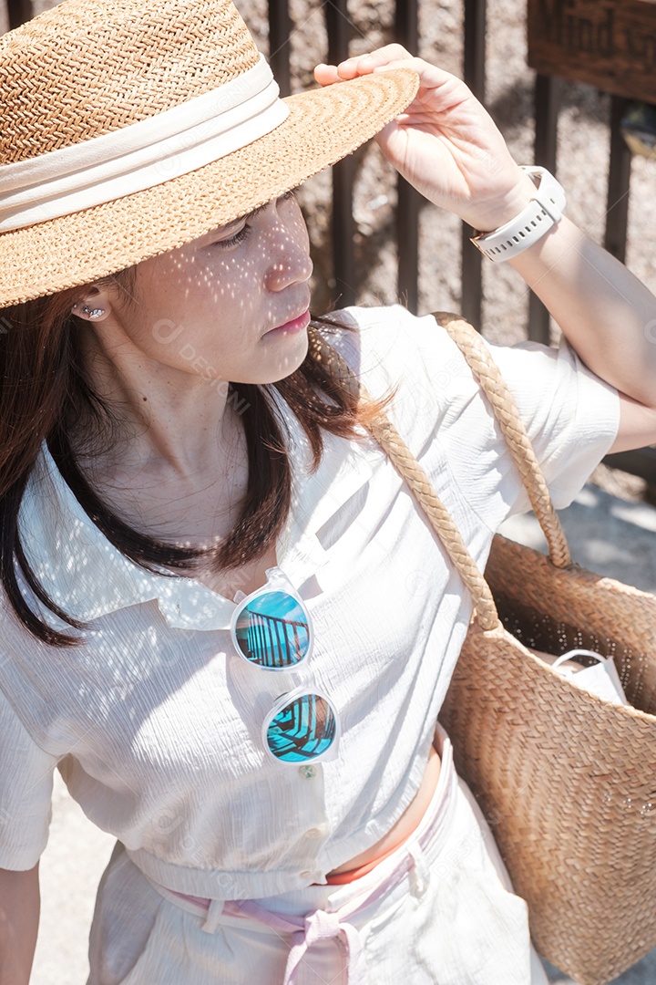Mulher viajante feliz no vestido branco e chapéu e, jovem de pé e olhando o oceano na praia tropical. Liberdade, relaxamento, férias de férias e conceito de viagens de verão
