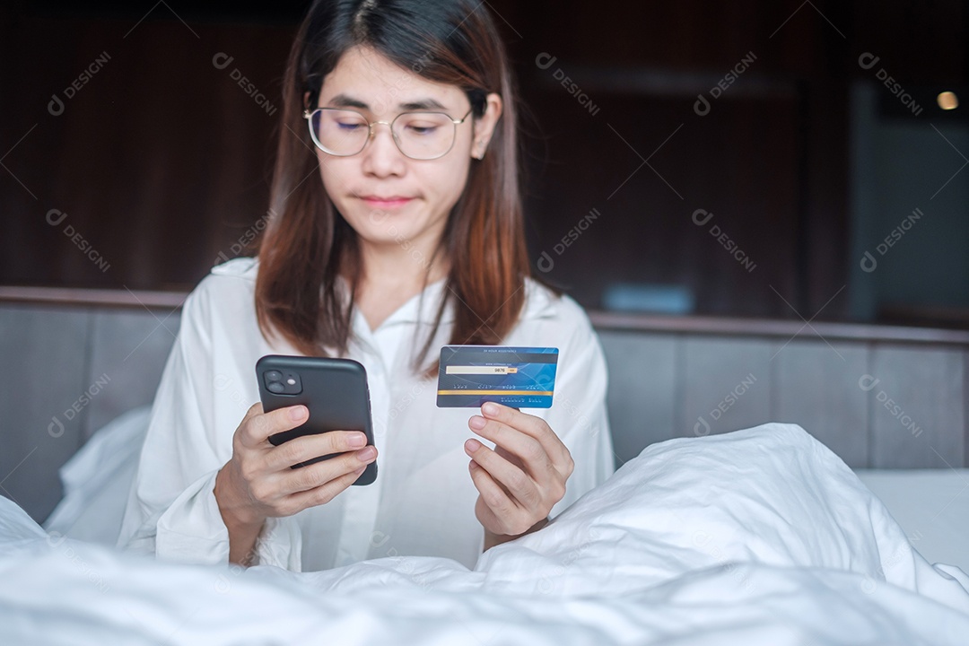 Mulher usando telefone inteligente móvel e cartão de crédito para compras online