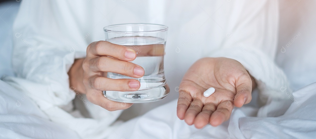 Mulher adulta segurando pílula e copo de água, mulher tomando médico