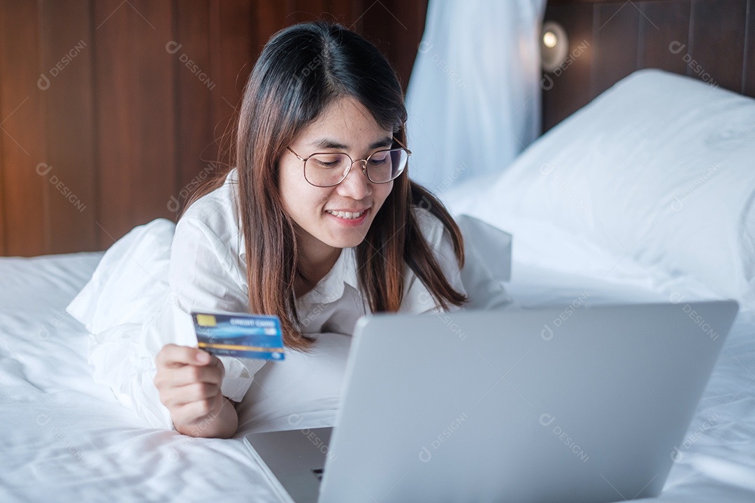 Mulher usando computador laptop e cartão de crédito para compras online