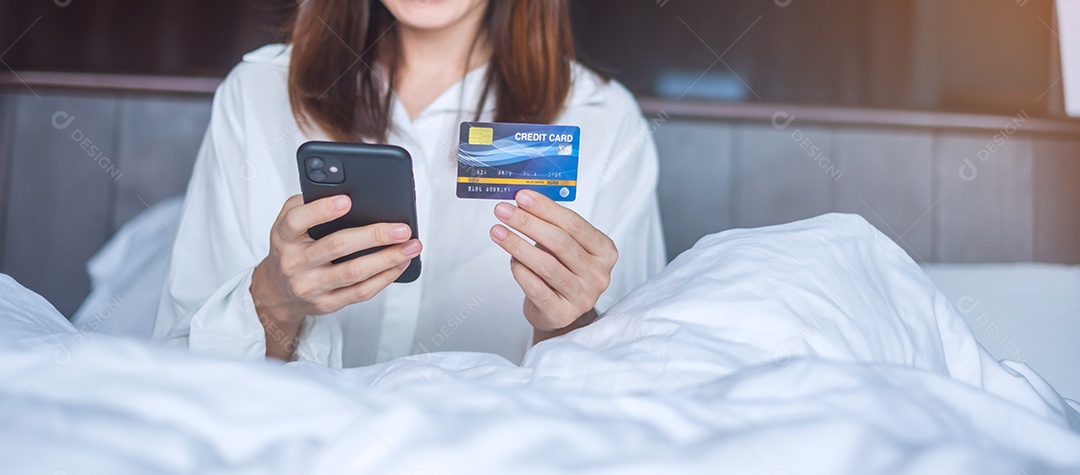 Mulher usando telefone inteligente móvel e cartão de crédito para compras online