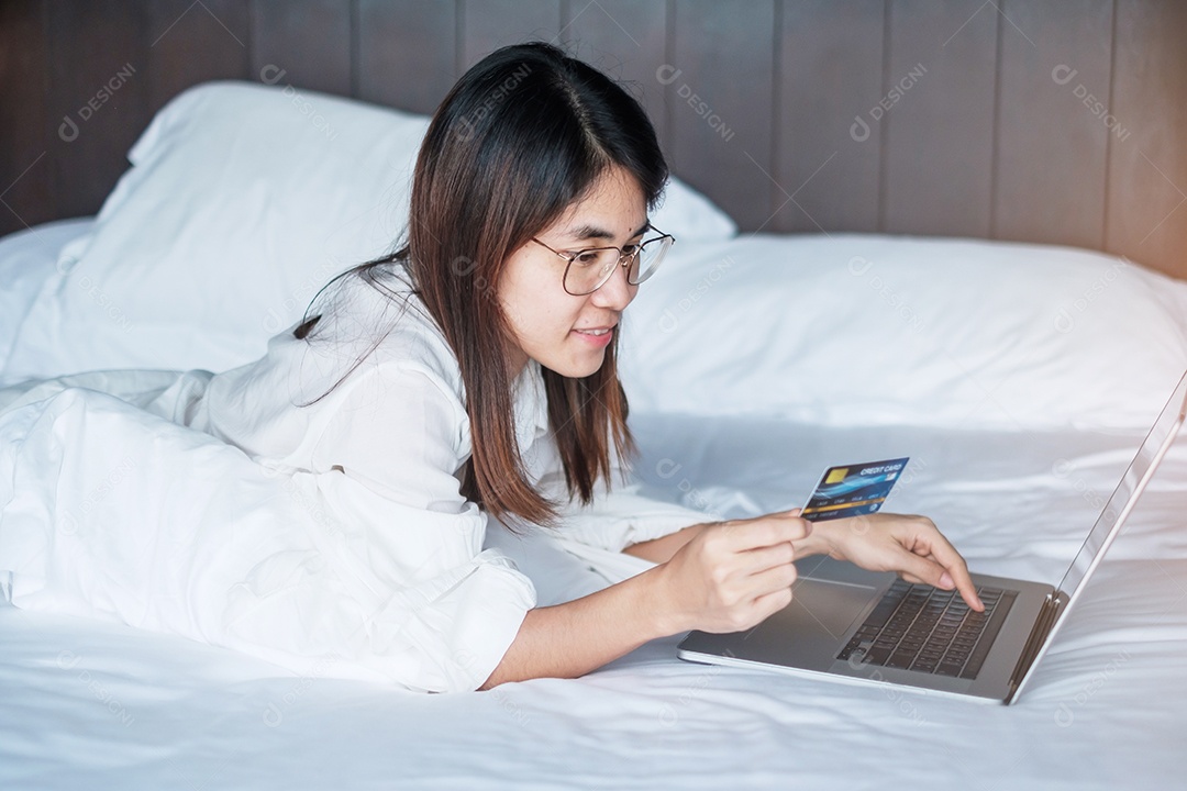 Mulher usando computador laptop e cartão de crédito para compras online