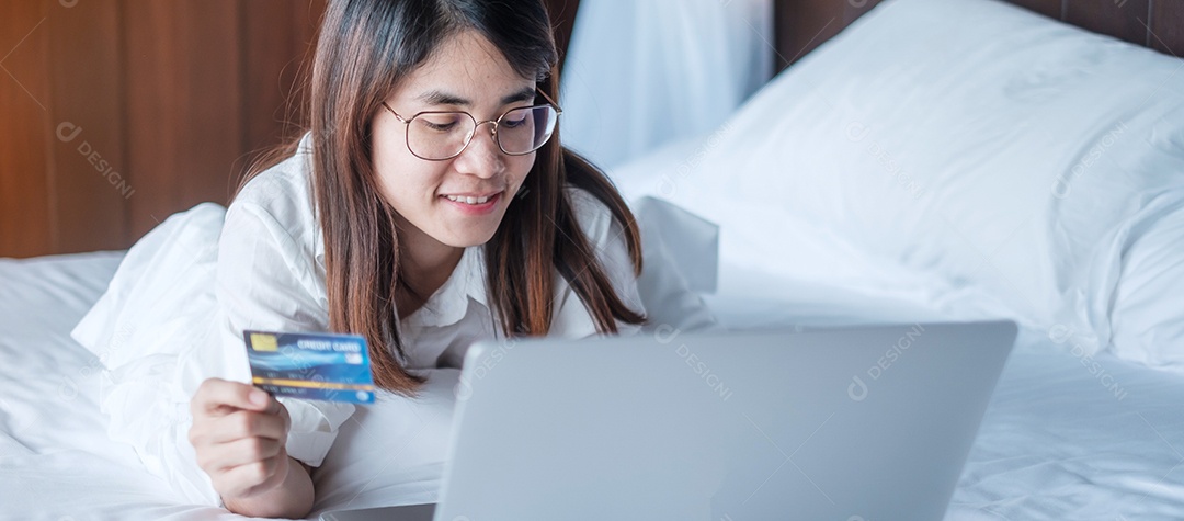 Mulher usando tablet e cartão de crédito para compras online.