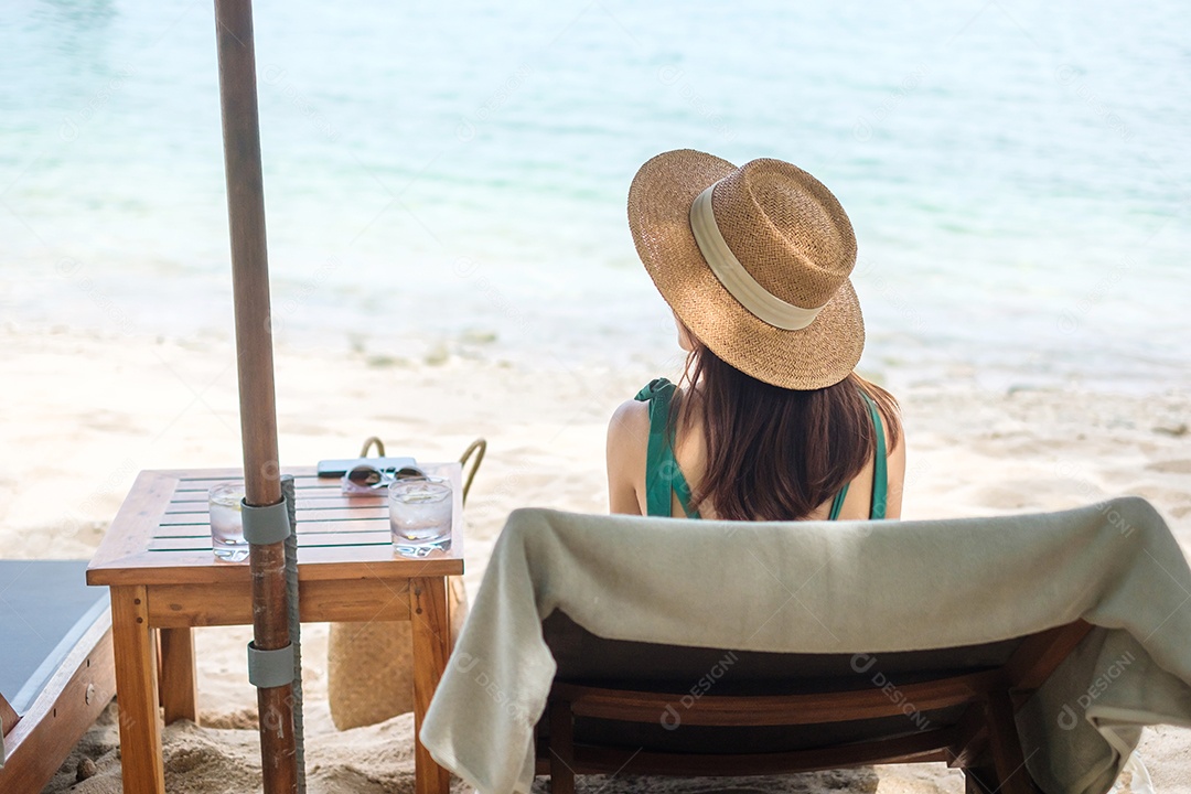 Mulher viajante feliz em trajes de banho verdes e chapéu desfruta de belos.