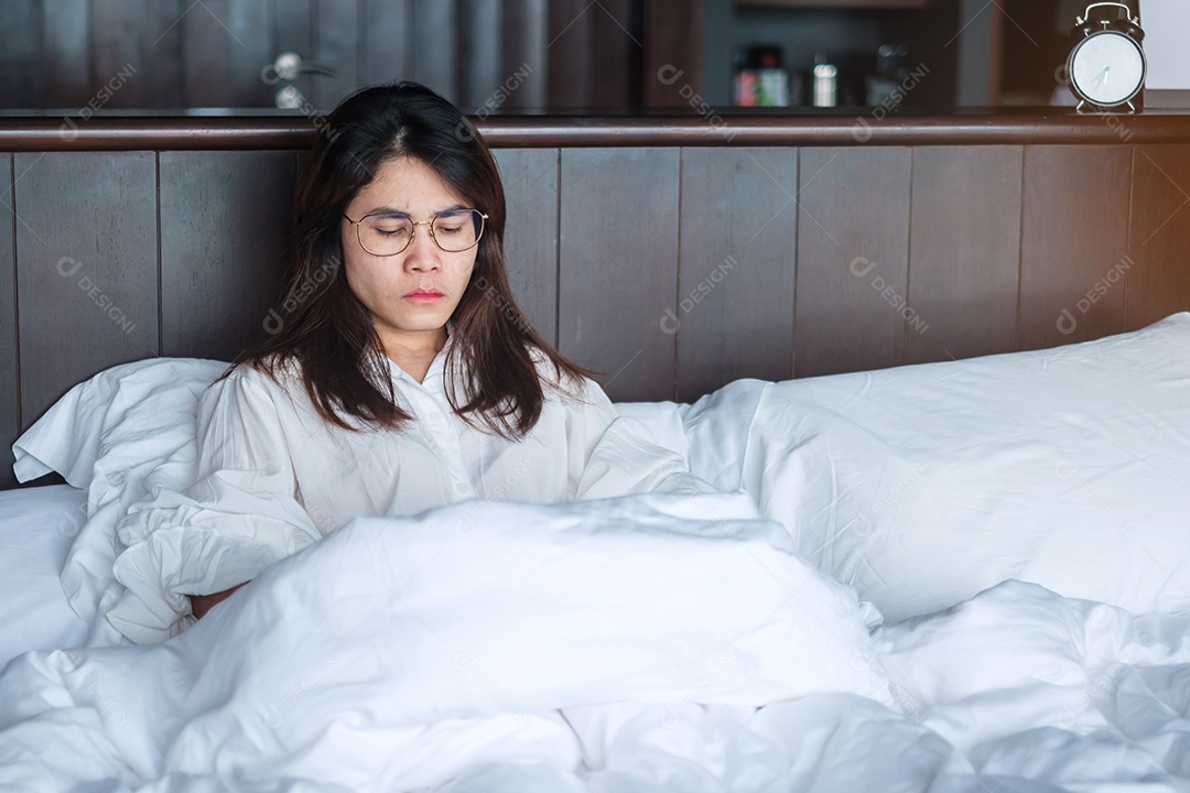 Mulher tendo enxaquecas durante a deitada na cama em casa.