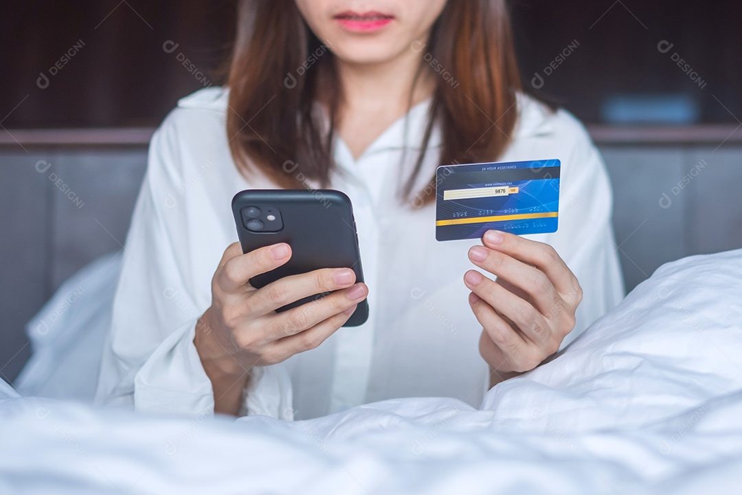 Mulher usando telefone inteligente móvel e cartão de crédito para compras online