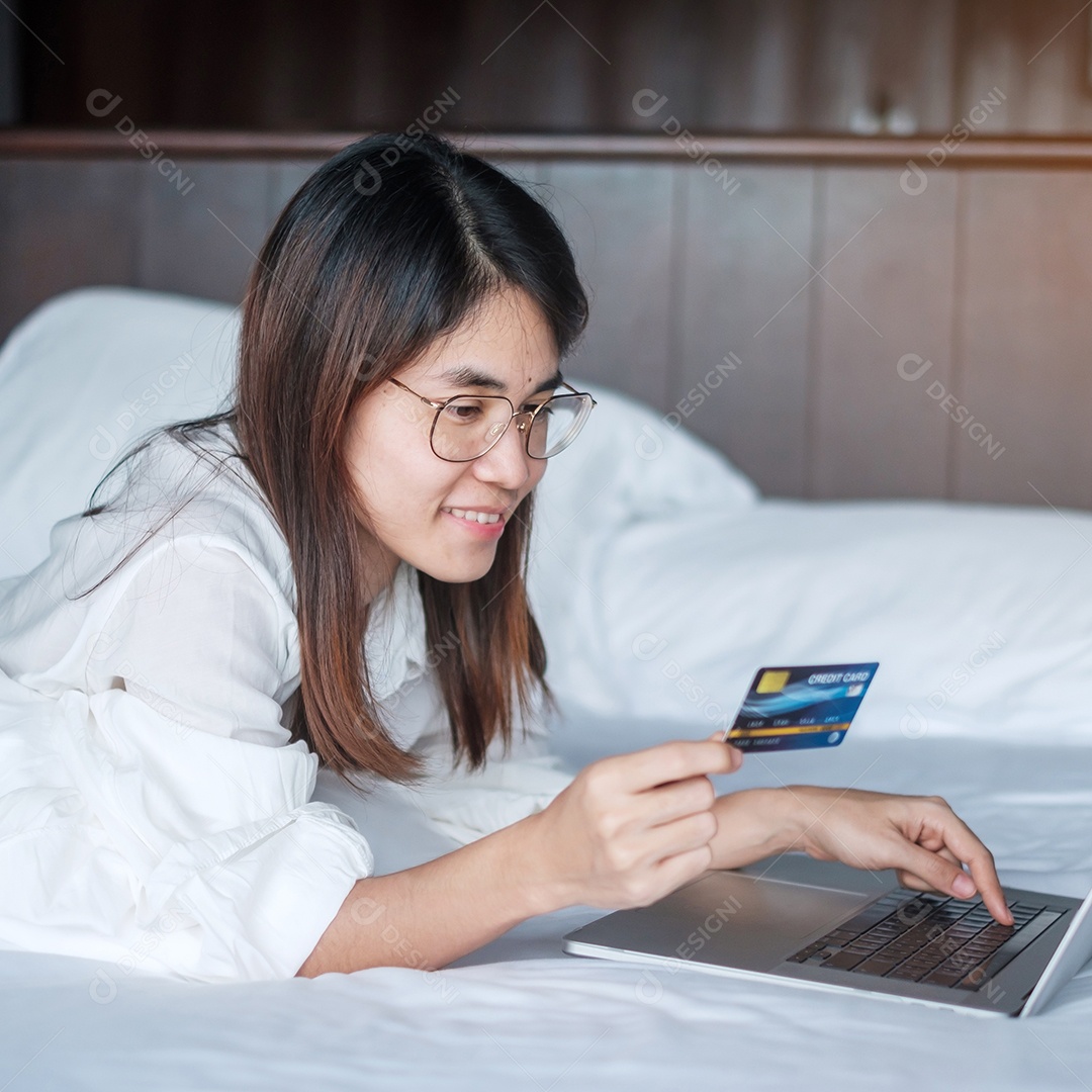 Mulher usando computador laptop e cartão de crédito para compras online