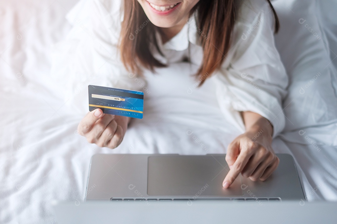 Mulher usando tablet e cartão de crédito para compras online.