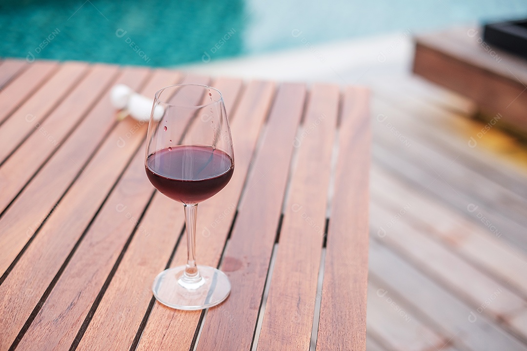 Taças de vinhos tintos perto da piscina. Viagens de verão, férias, férias e conceito de fim de semana feliz