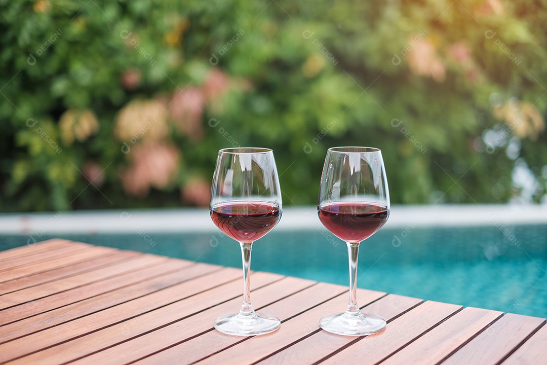 Dois copos de vinhos tintos perto da piscina. Viagens de verão, férias, férias e conceito de fim de semana feliz