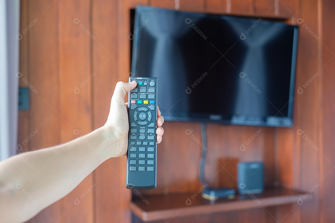 Mão usando o controle remoto para ajustar a TV dentro do modo.