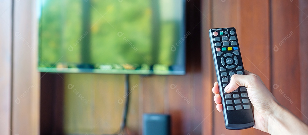 Mão usando o controle remoto para ajustar a TV dentro do modo.