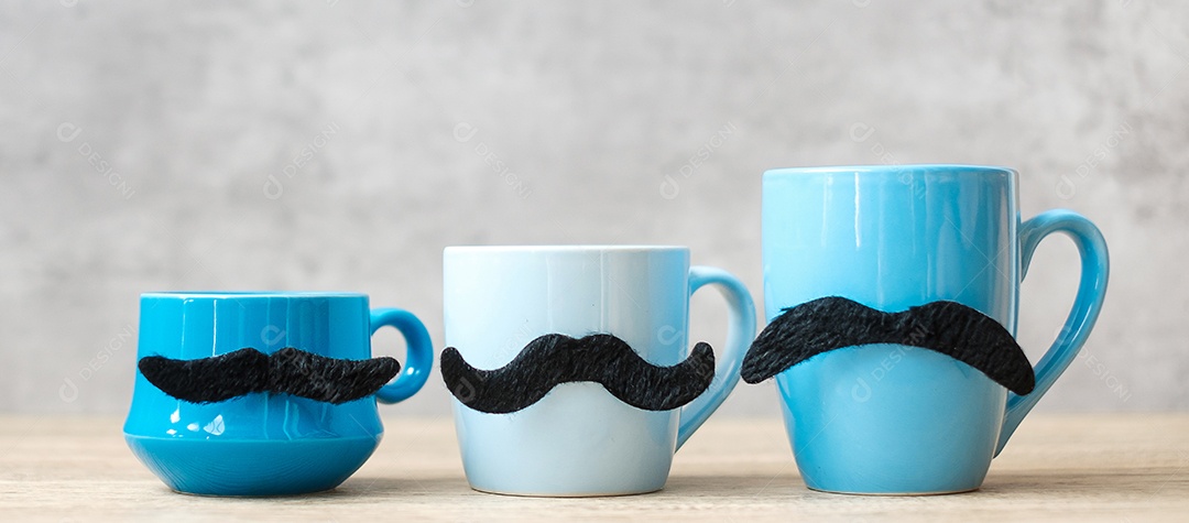 Xícara de café azul e caneca de chá com decoração de bigode preto em madeira.
