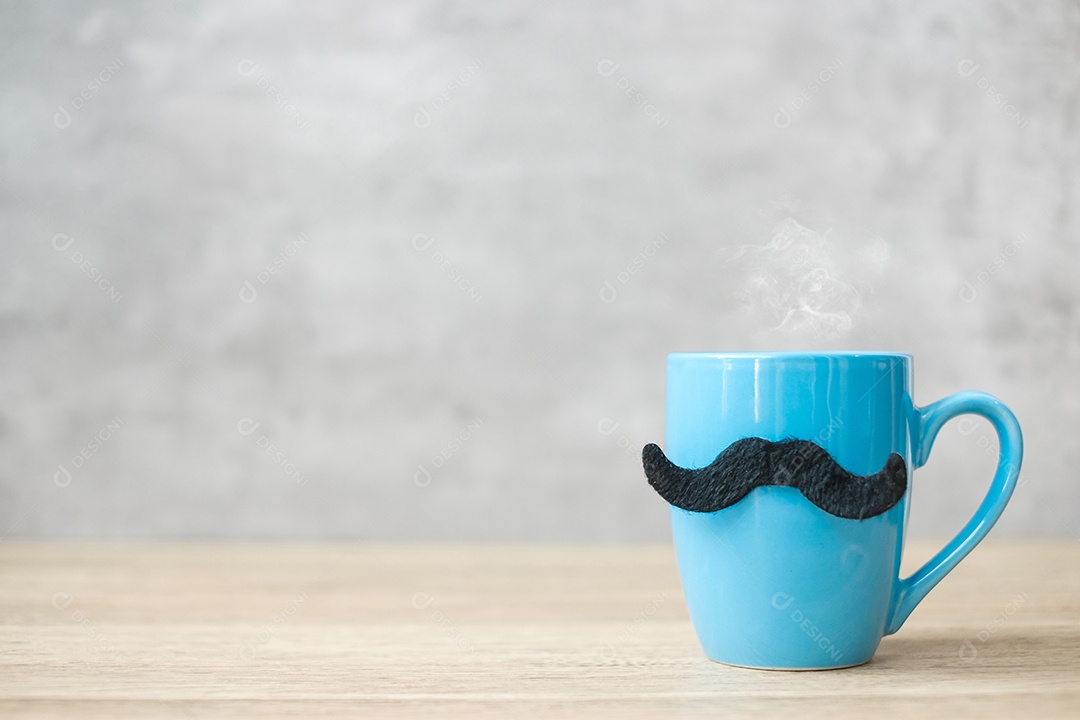 Xícara de café azul ou caneca de chá com decoração de bigode preto na mesa.