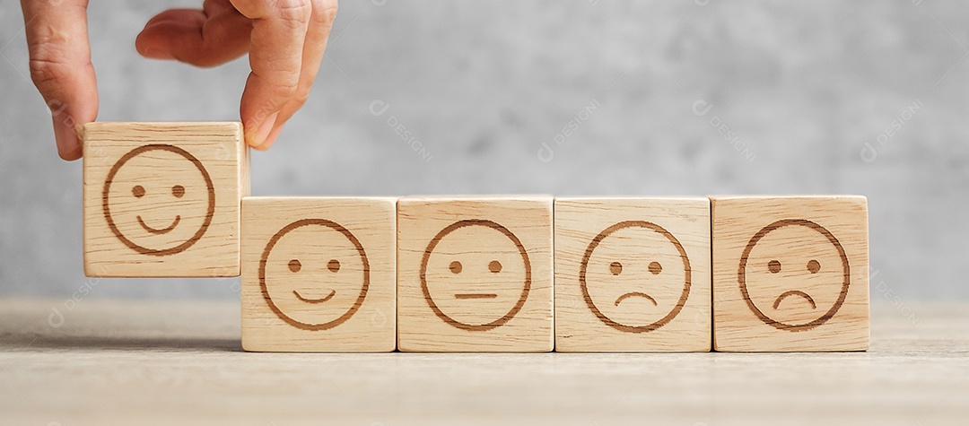 Mão de homem segurando o bloco de rosto de emoção. Cliente escolhe Emoticon.