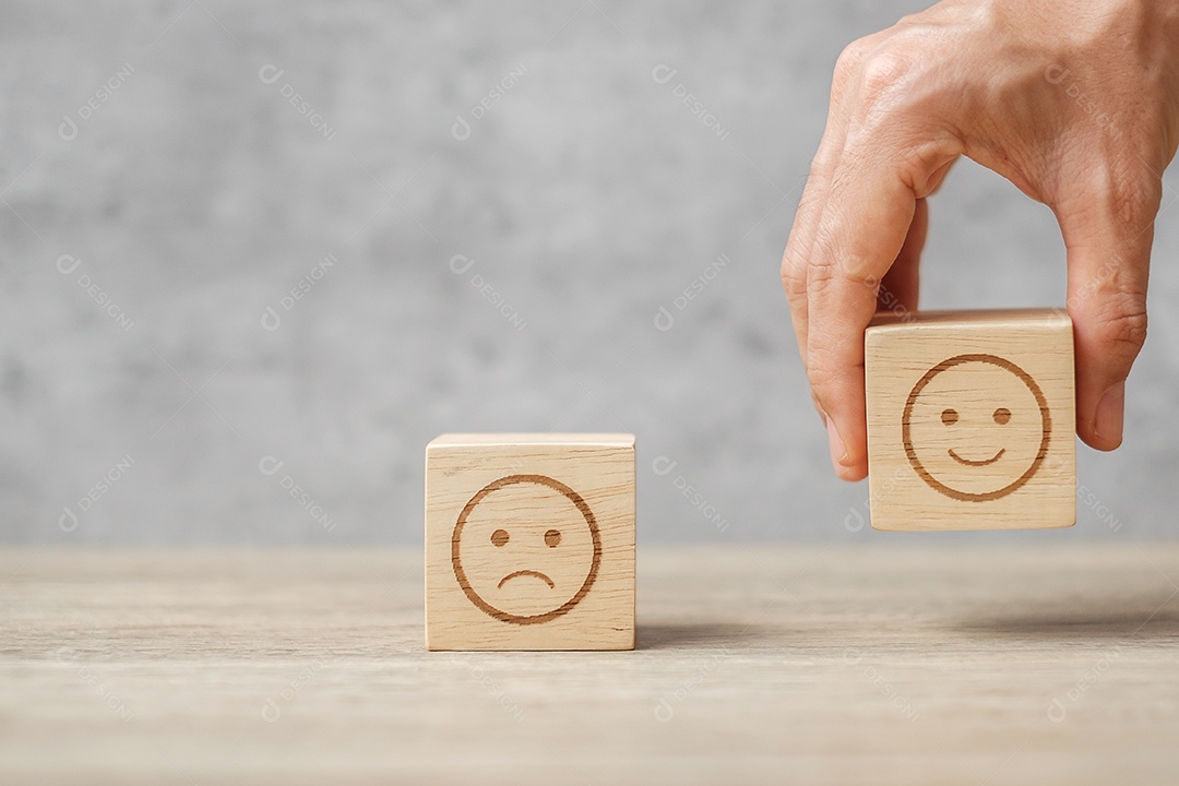 Mão segurando o bloco de rosto de sorriso. O cliente escolhe o Emoticon para o usuário